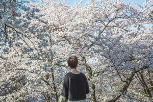 woman looking at white flowered trees